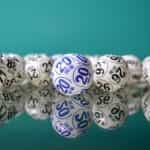 Bingo draw balls sit on top of a reflective surface.