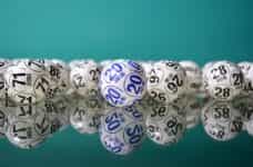 Bingo draw balls sit on top of a reflective surface.