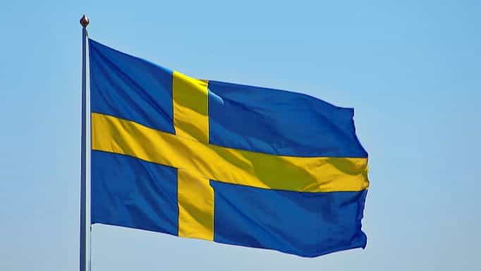 Bendera Swedia melawan langit biru cerah di siang hari.