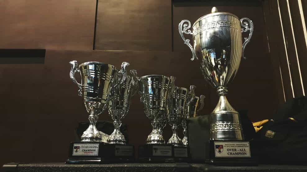 Piala perak dengan berbagai ukuran duduk di rak.