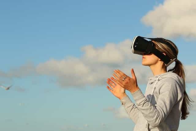 Seorang wanita mengenakan headset Virtual Reality.
