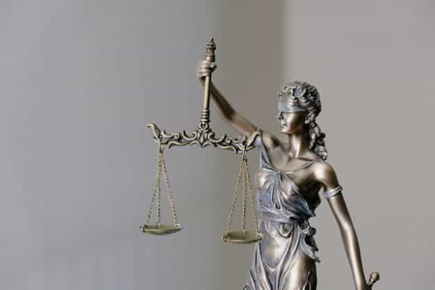 Patung Keadilan dengan penutup mata memegang timbangan.