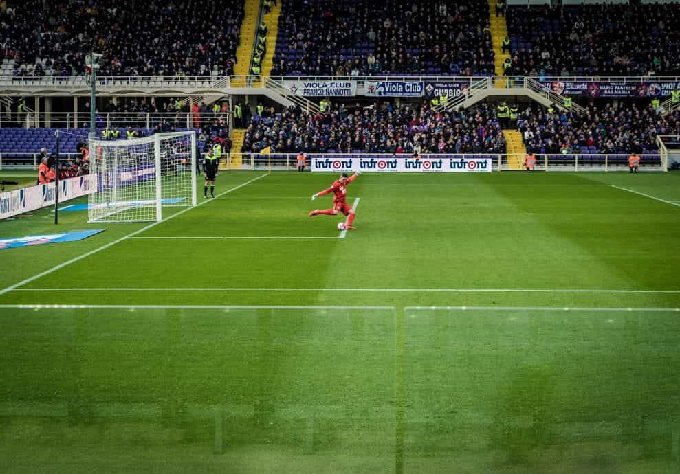 Orang-orang bermain sepak bola di lapangan stadion pada malam hari di Florence, Italia.