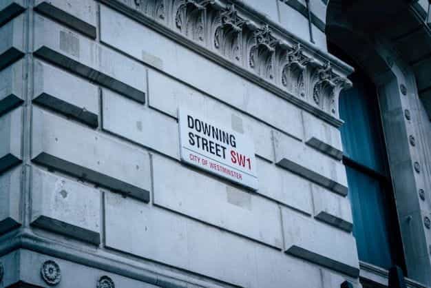 Sebuah tanda jalan bertuliskan DOWNING STREET SW1 di sebuah sudut di London, Inggris.
