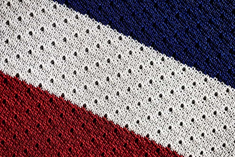 Sepotong kain rajutan bertuliskan tiga warna bendera Prancis.