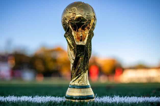 Replika trofi Piala Dunia sepak bola ditempatkan di sepanjang garis lapangan sepak bola.
