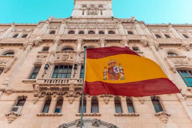 Bendera Spanyol melambai di depan sebuah gedung besar di Madrid.