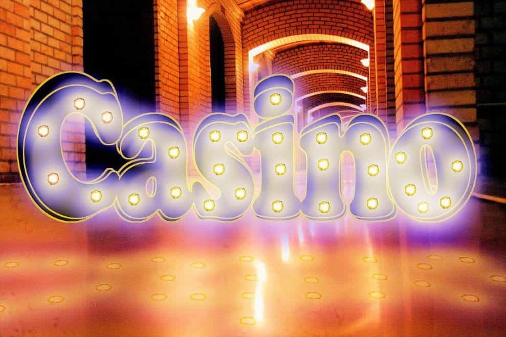 A large graphic of the word casino on the floor of a long hallway inside of a building.
