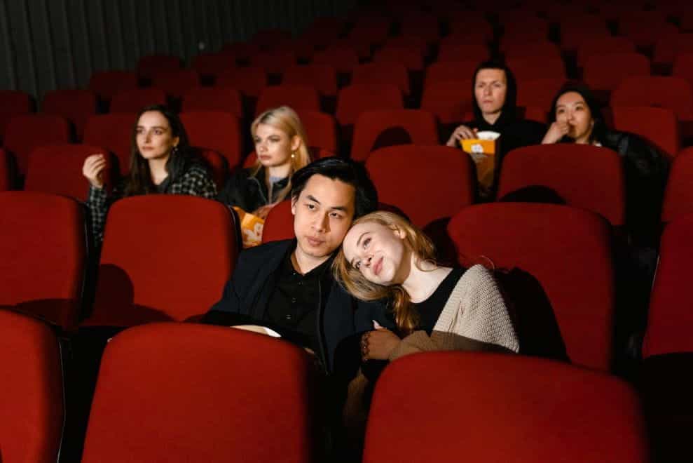 Orang-orang duduk di kursi di bioskop.