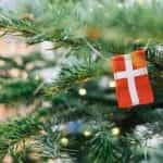 A miniature Denmark flag hangs off a Christmas tree.