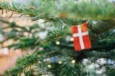 A miniature Denmark flag hangs off a Christmas tree.