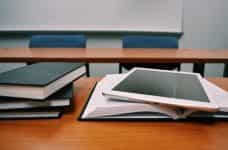 Books and an iPad on a school desk.