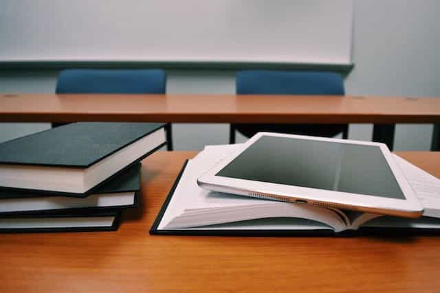 Buku dan iPad di meja sekolah.