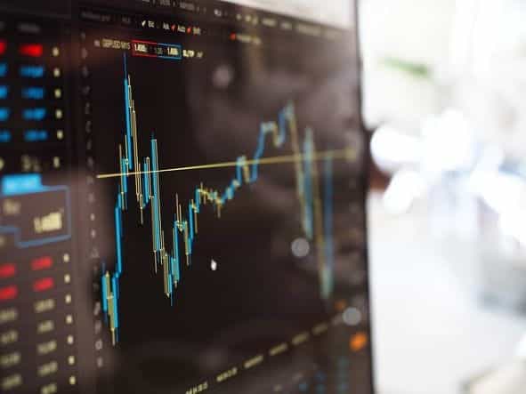 Monitor yang menampilkan grafik saham di pasar keuangan.