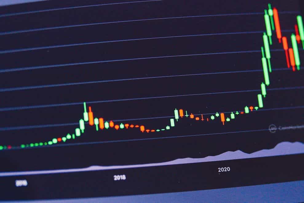 A trading chart on a laptop screen showing an upward trend.
