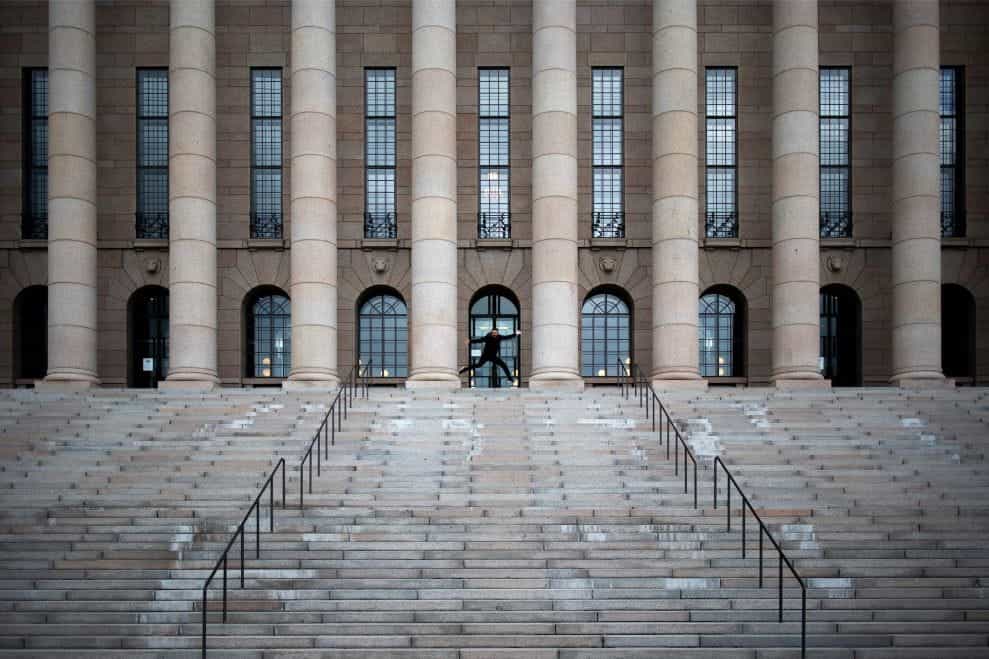 Anak tangga menuju Parlemen Finlandia dengan satu orang menunjuk ke puncak tangga.