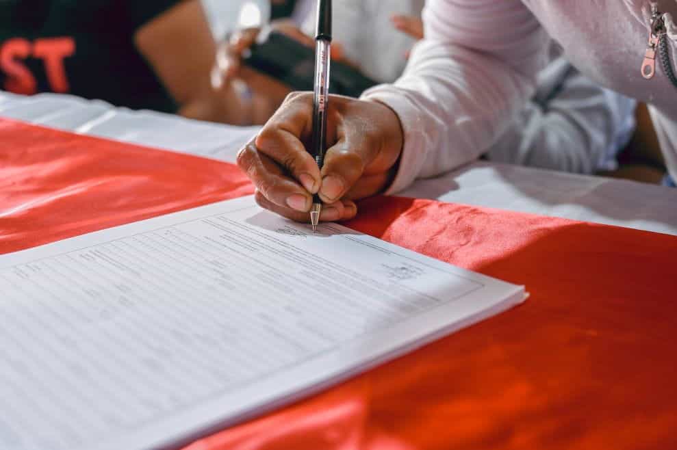 A woman signs a document.