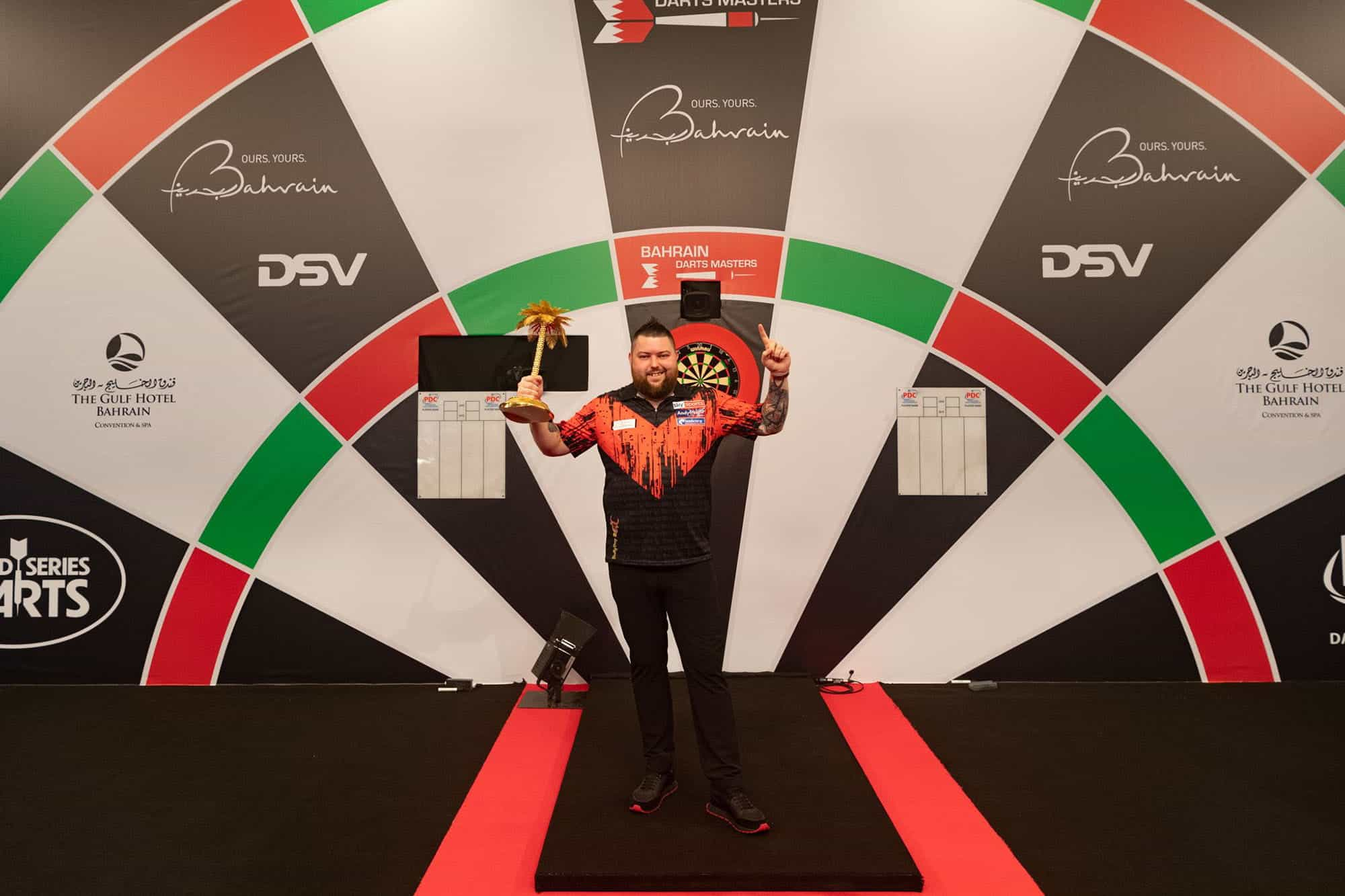 Pemenang Michael Smith berpose dengan trofi Bahrain Darts Masters miliknya.