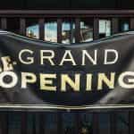 A large banner sign reads RE-GRAND OPENING.