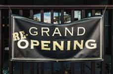 A large banner sign reads RE-GRAND OPENING.
