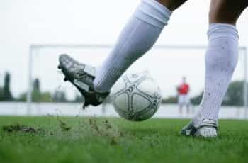 A footballer kicking a ball.