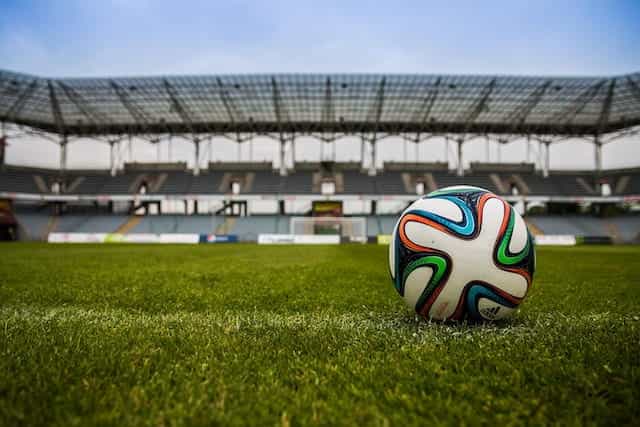 Sebuah sepak bola di lapangan rumput di sebuah stadion.