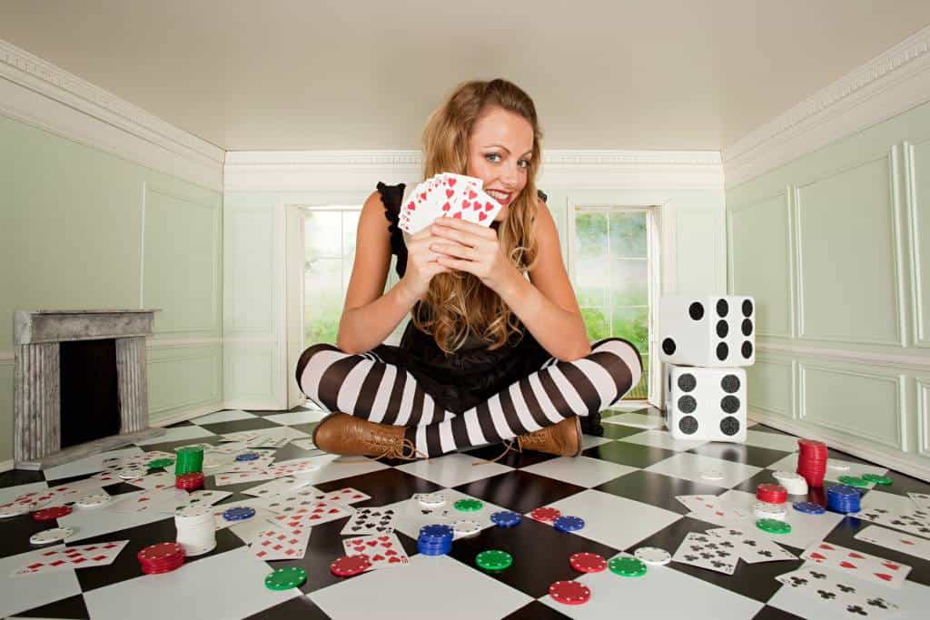 Seorang wanita muda di ruangan kecil dengan bermain kartu dan dadu.