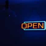 A red and blue neon sign displaying the word Open on the wall of a business.