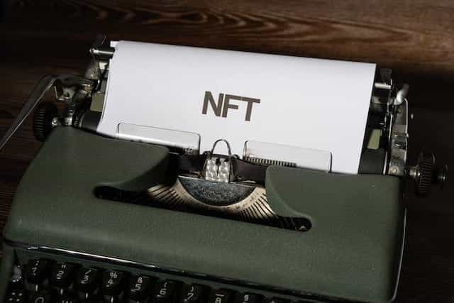 Mesin tik dengan tulisan NFT di atas kertas.