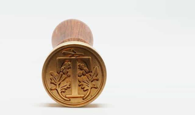 Ujung cetakan stempel kayu ditampilkan, dengan desain bunga.