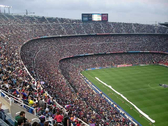 Sebuah stadion olahraga besar dipenuhi penonton yang menonton acara olahraga berskala besar.