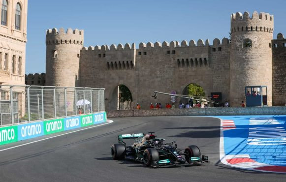 A Mercedes F1 car races alone around the Baku Street Circuit in 2021.