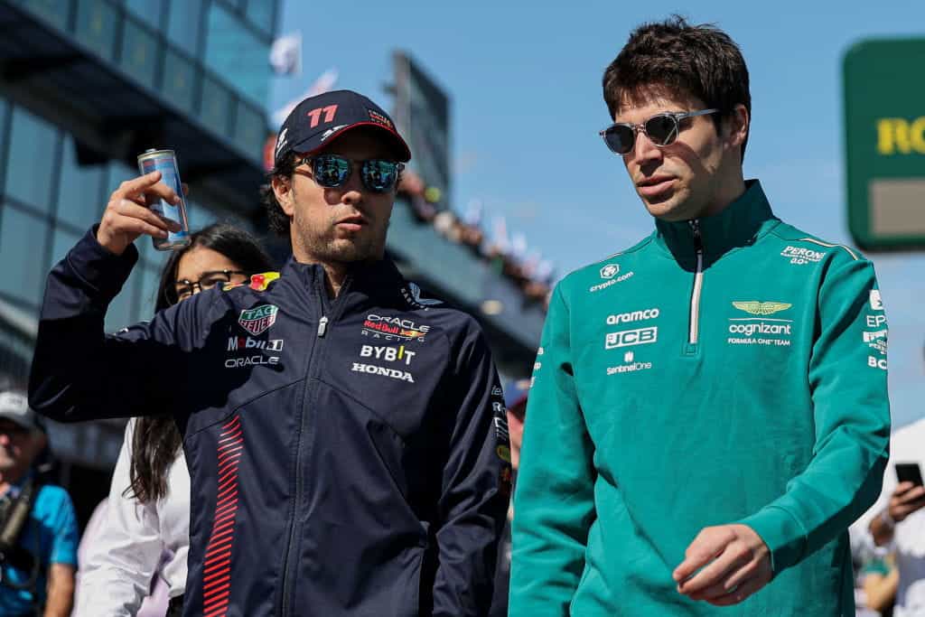 Sergio Perez and Lance Stroll walk to the starting grid together ahead of the 2023 Australian Grand Prix.