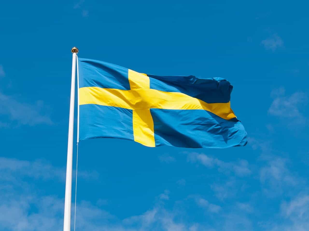 Bendera Swedia berkibar tertiup angin di hari yang cerah.