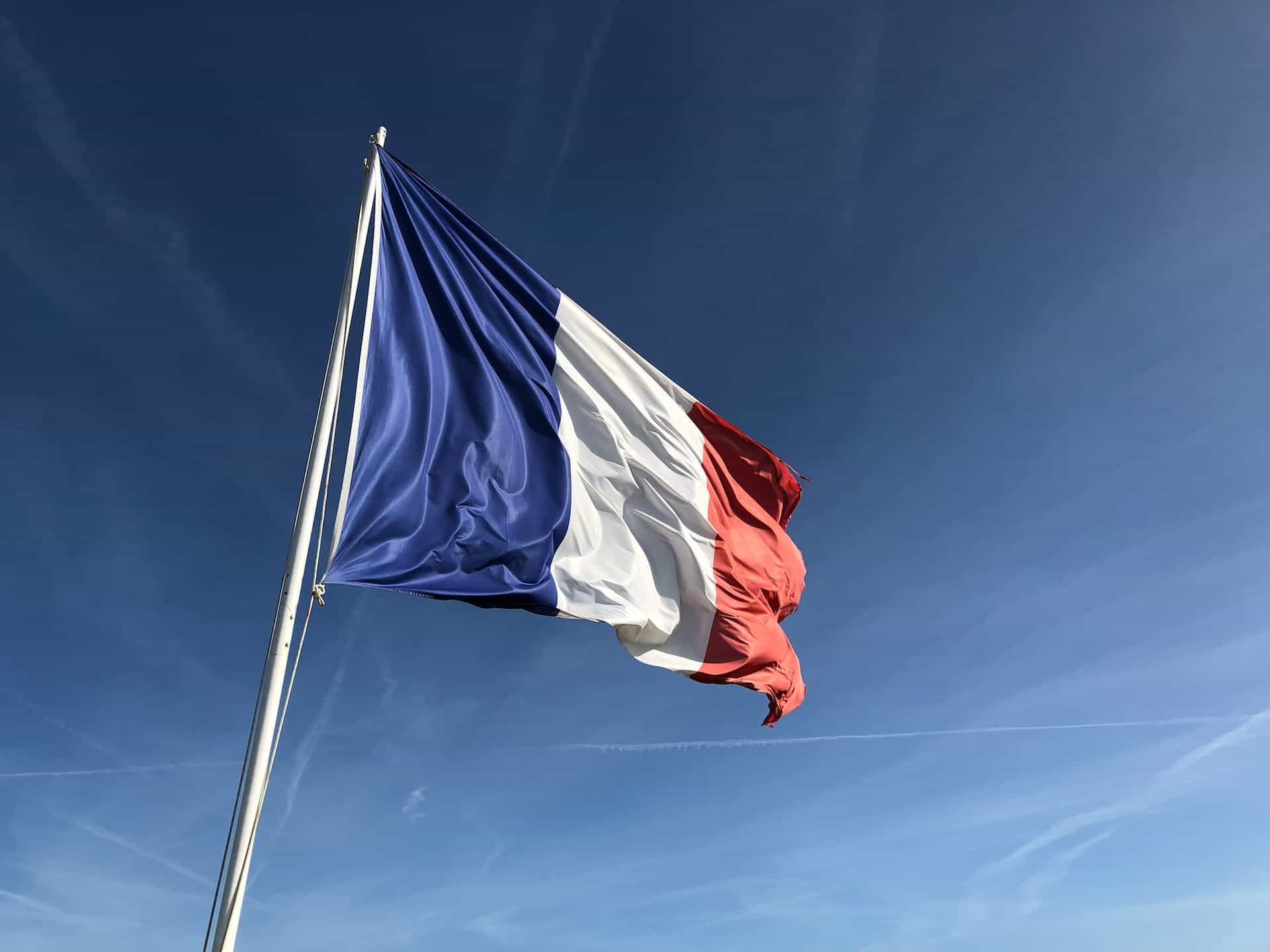 Bendera Prancis berkibar di langit biru.