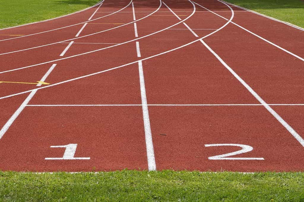 A clay outdoor athletic field featuring two running lanes labeled ‘1’ and ‘2’ respectively. 