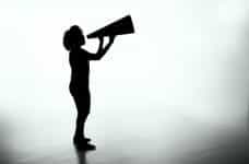 A silhouette of a woman holding a megaphone.