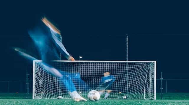 Foto selang waktu seorang pemain mencoba menendang ke gawang sepak bola.
