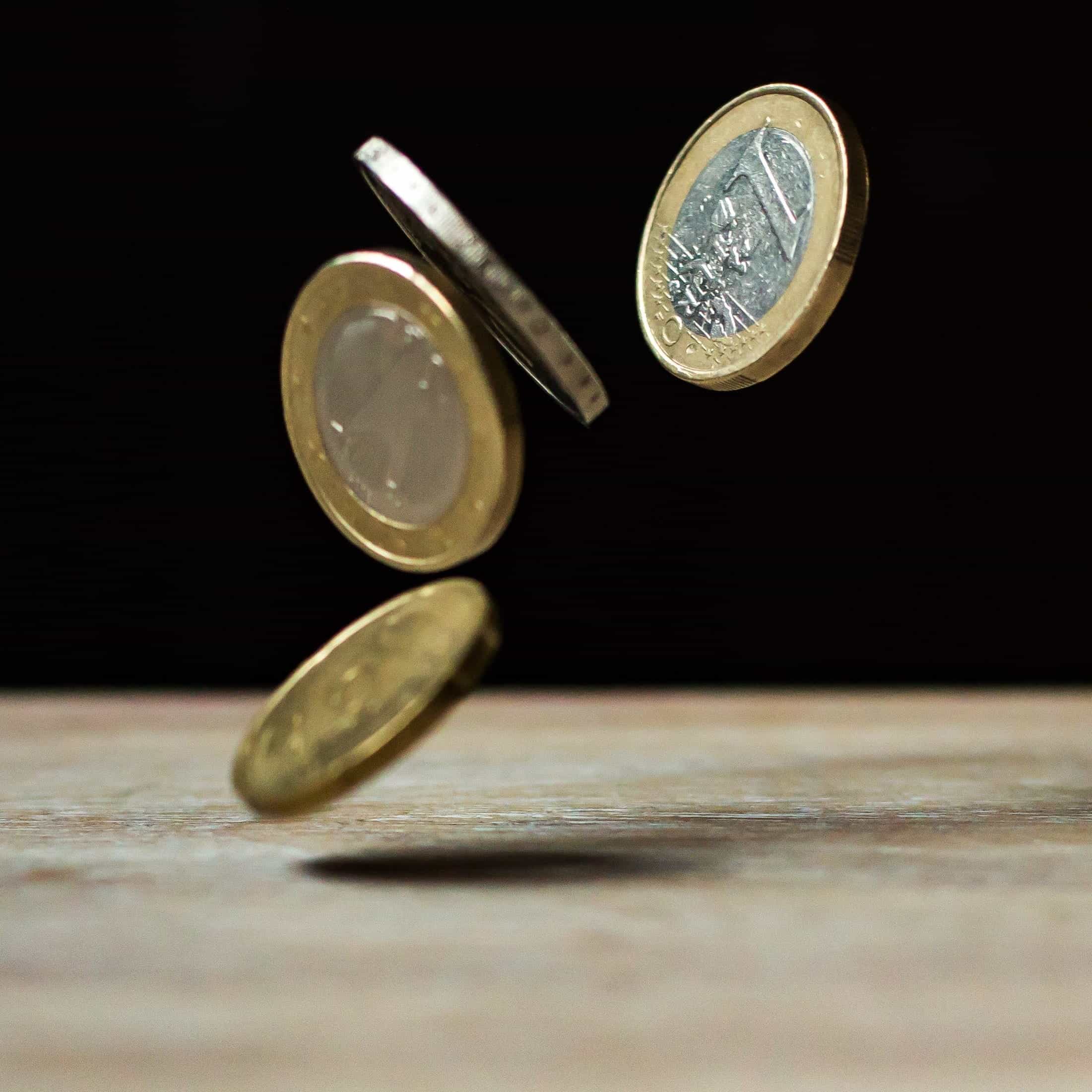 Euro coins falling onto a table.