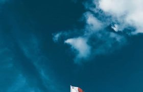 The flag of Malta flying over Valetta city.