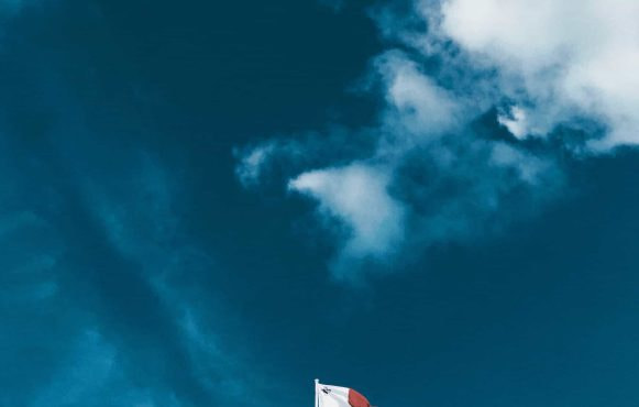 The flag of Malta flying over Valetta city.