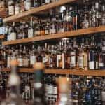 Shelves of liquor bottles lined up behind a bar.