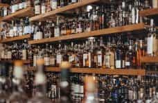 Shelves of liquor bottles lined up behind a bar.
