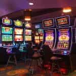 Several brightly lit slot machines in a casino room.
