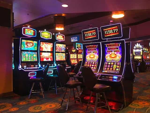 Beberapa mesin slot yang terang benderang di ruang kasino.