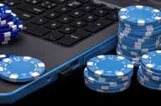 Poker chips next to a laptop