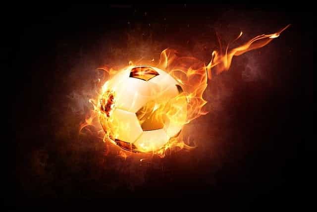 Sebuah bola sepak terbang di udara saat terbakar.