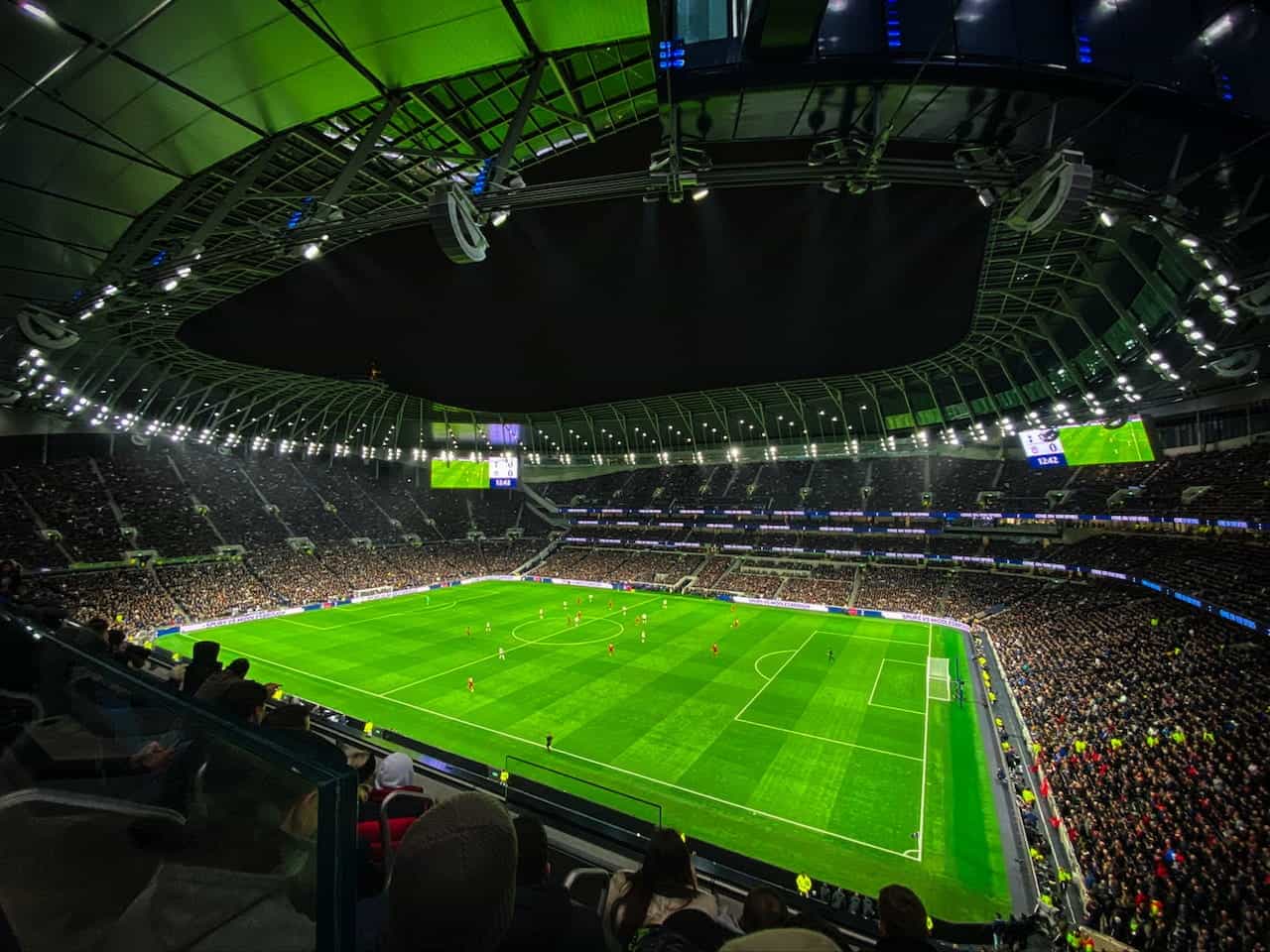 Fans watching a football match in a stadium.