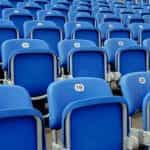 Blue chairs in a football stadium.