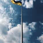 Flag of Ukraine flying against a blue sky.